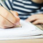 Kid Writing in Notebook.